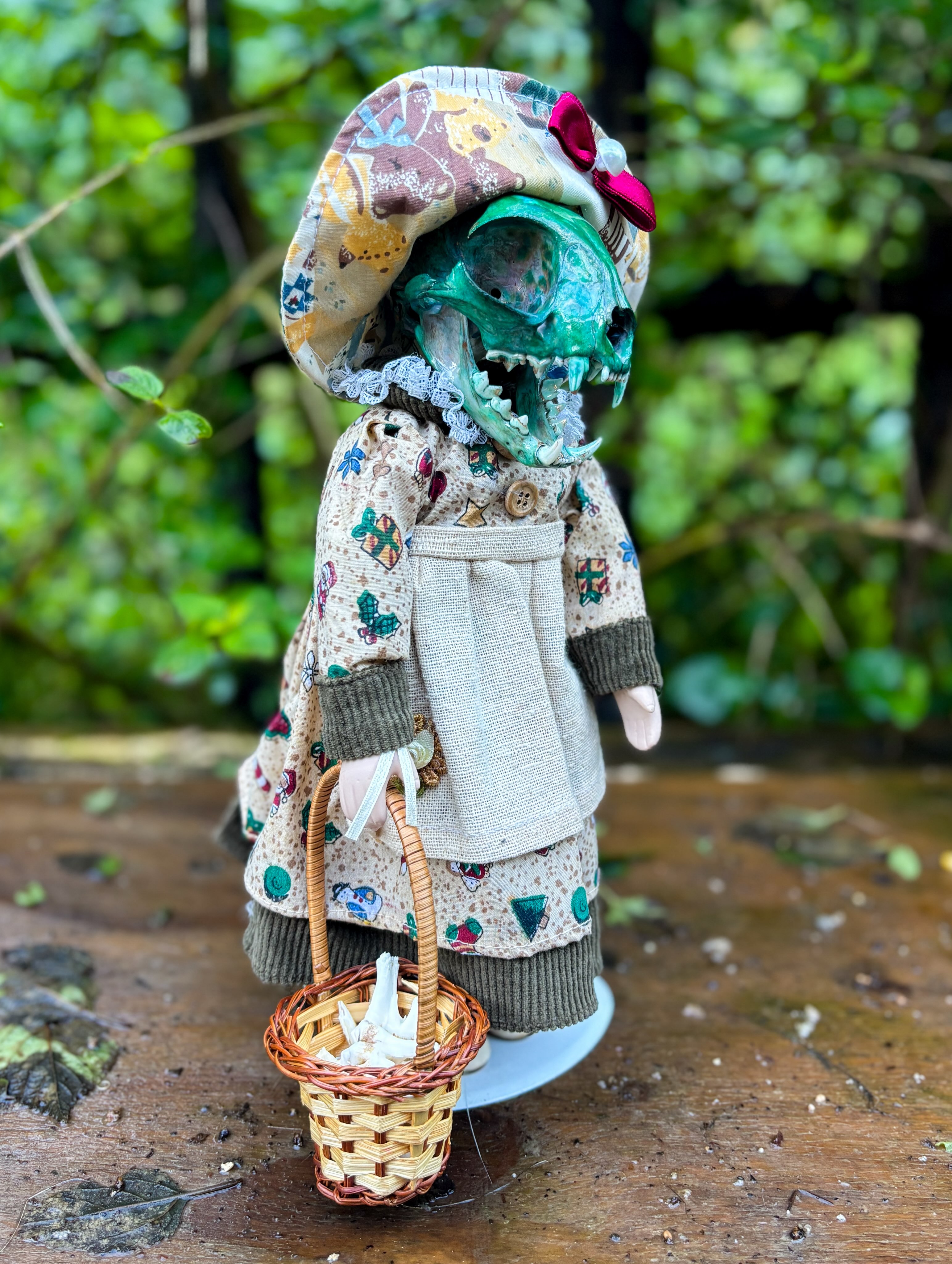 Moira — A dyed cat skull meets a porcelain doll, carrying a tiny basket filled with teeth.
