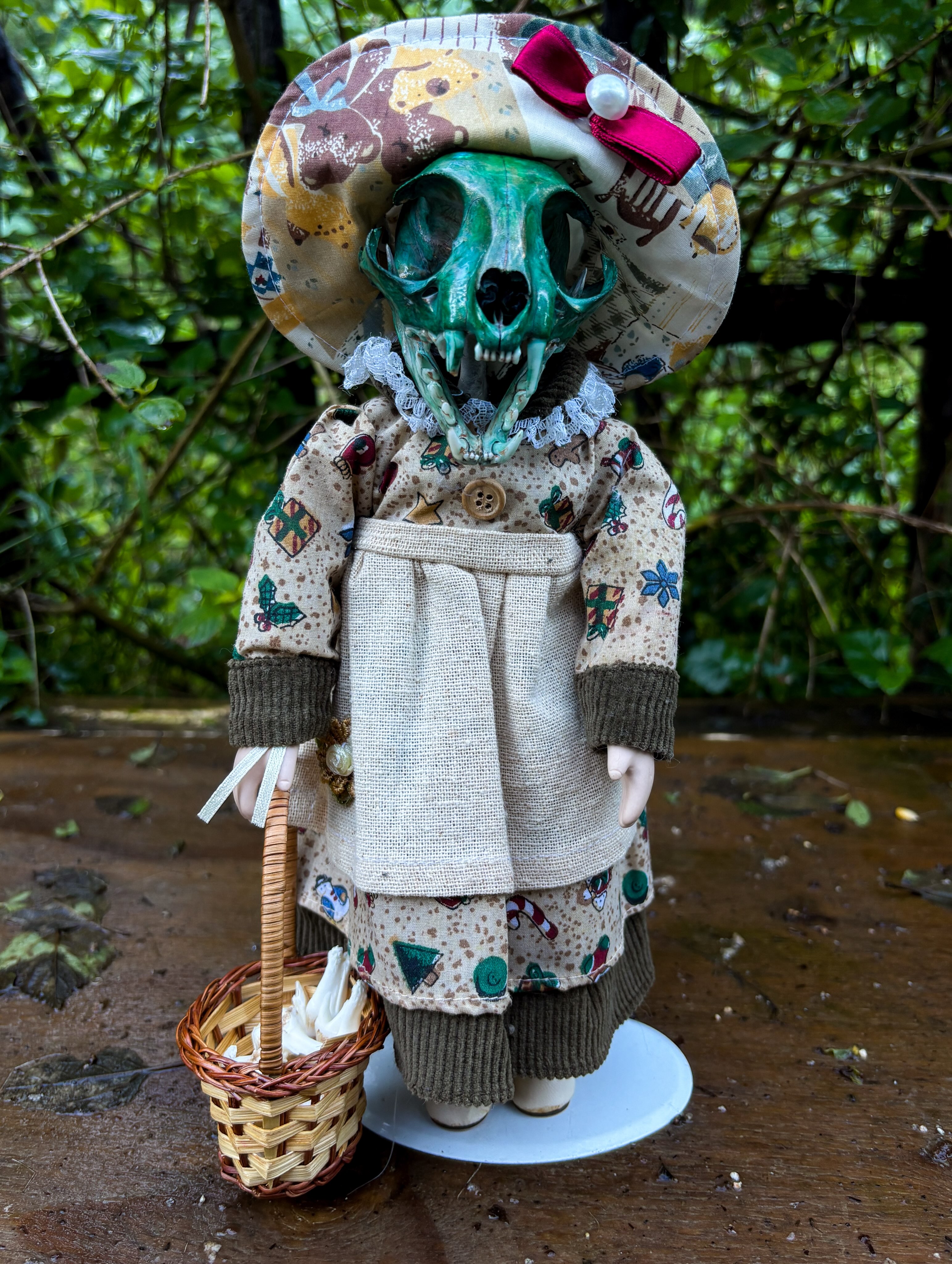 Moira — A dyed cat skull meets a porcelain doll, carrying a tiny basket filled with teeth.